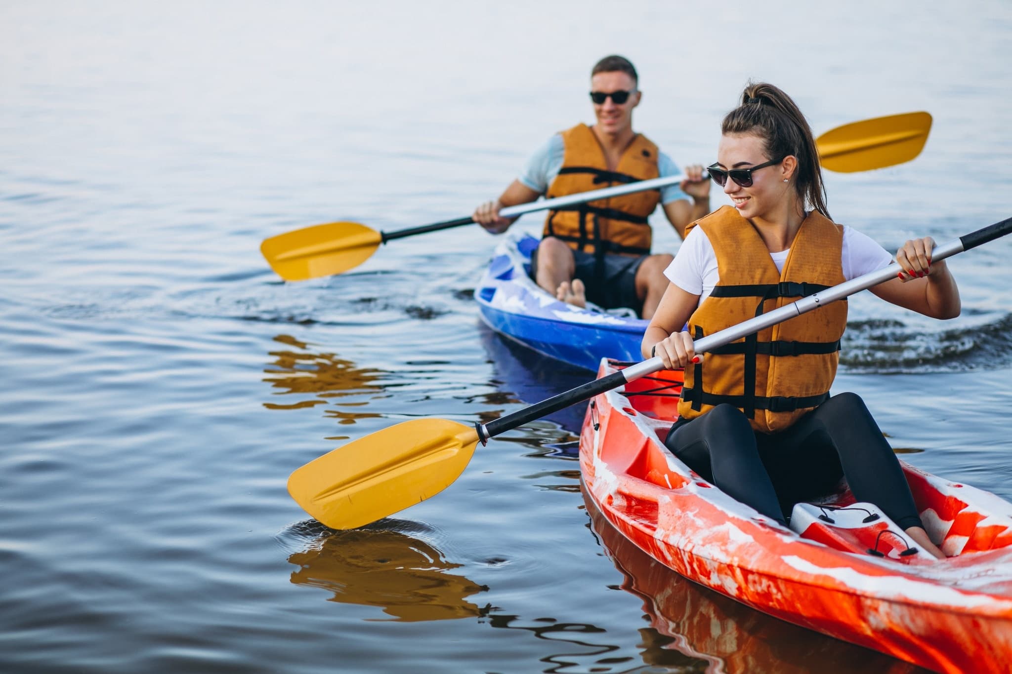 Group of kayakers paddling together on calm lake excursion