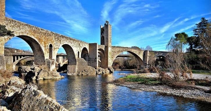 Medieval stone bridge over river in Girona region, scenic walk