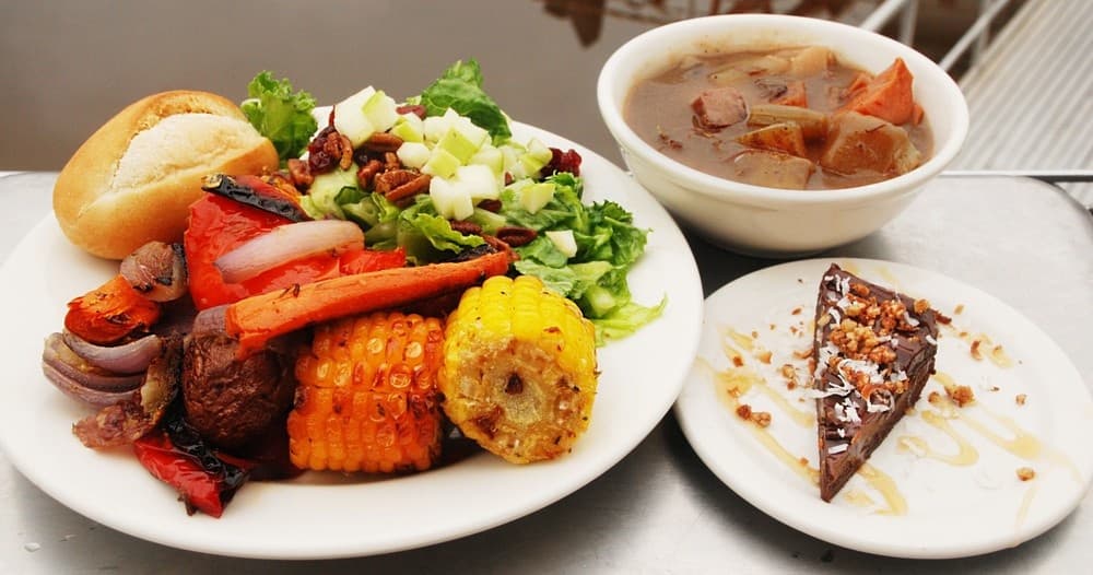 Plated barbecue and corn with dessert in tour boat galley