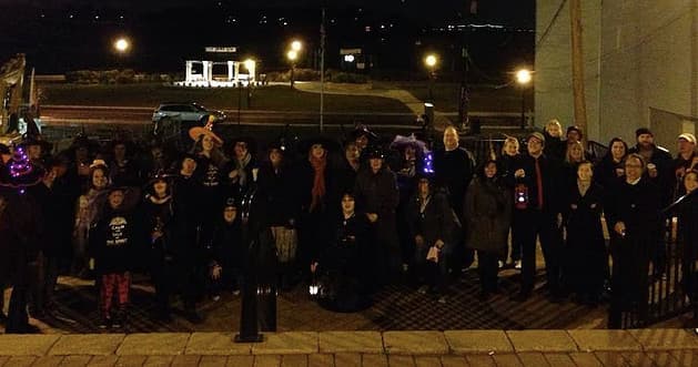 Outdoor group ghost tour posing on steps near Jersey Shore night