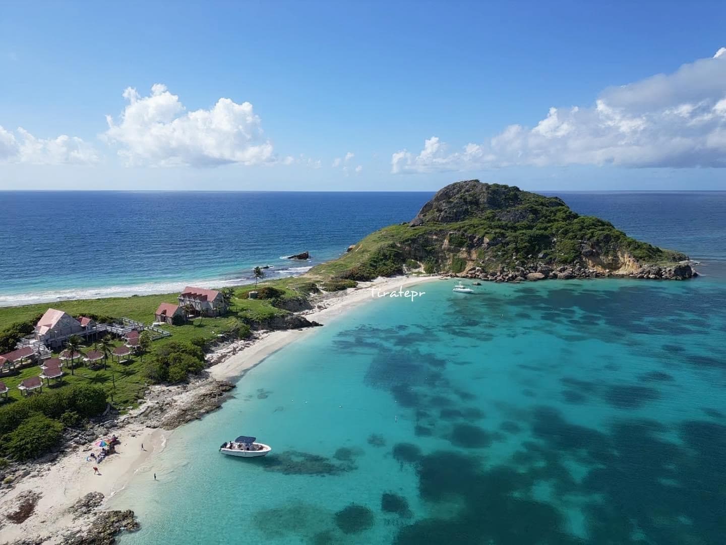 Aerial view of tropical island and turquoise bay with boat