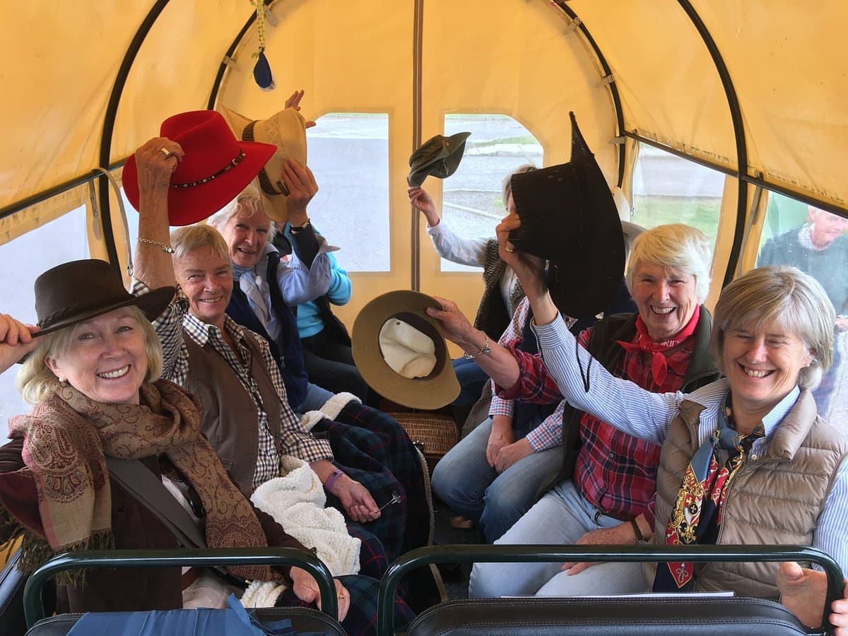 Group enjoying covered wagon ride on scenic countryside tour