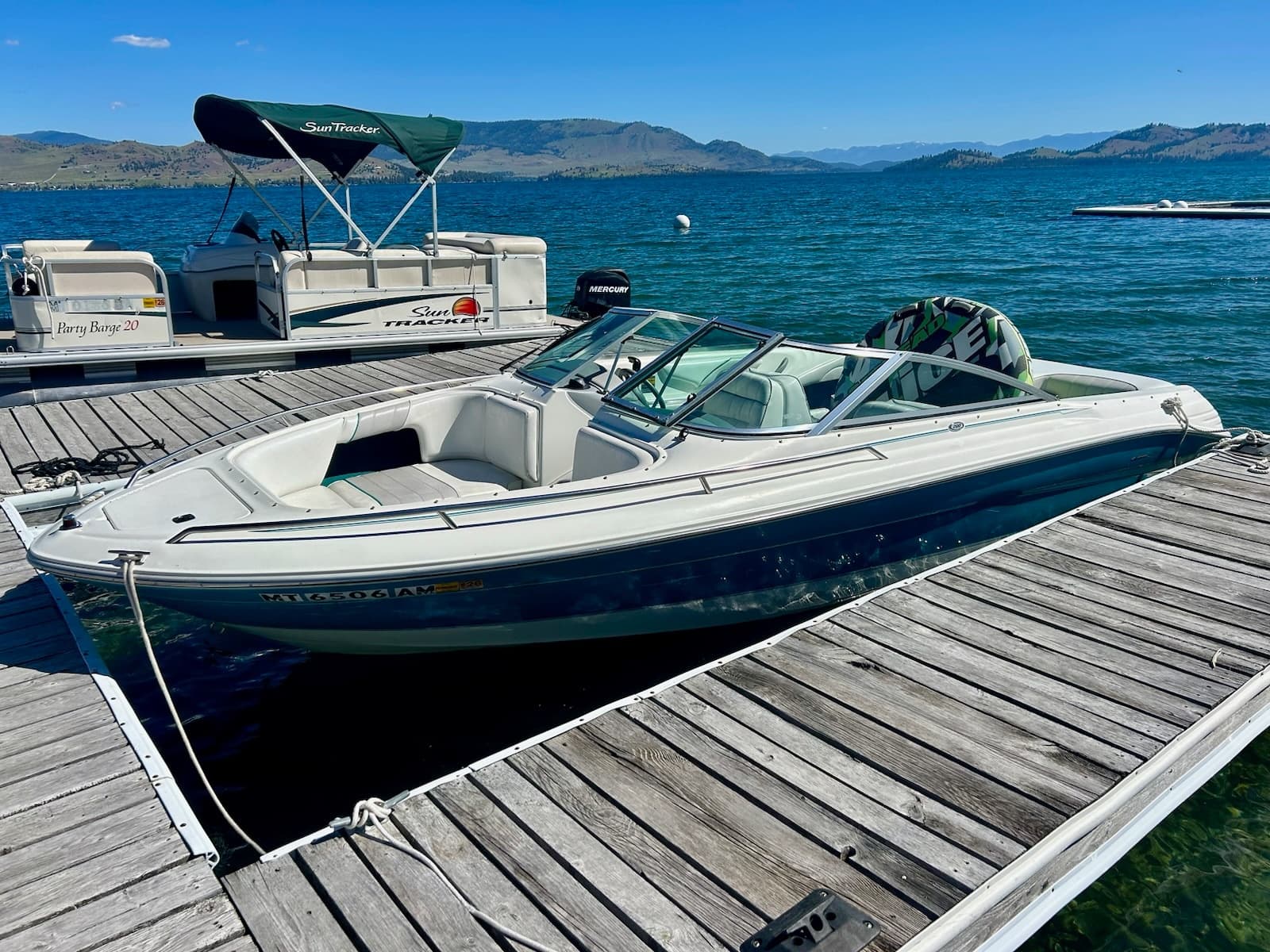 Powerboat moored at sunny marina on blue mountain lake