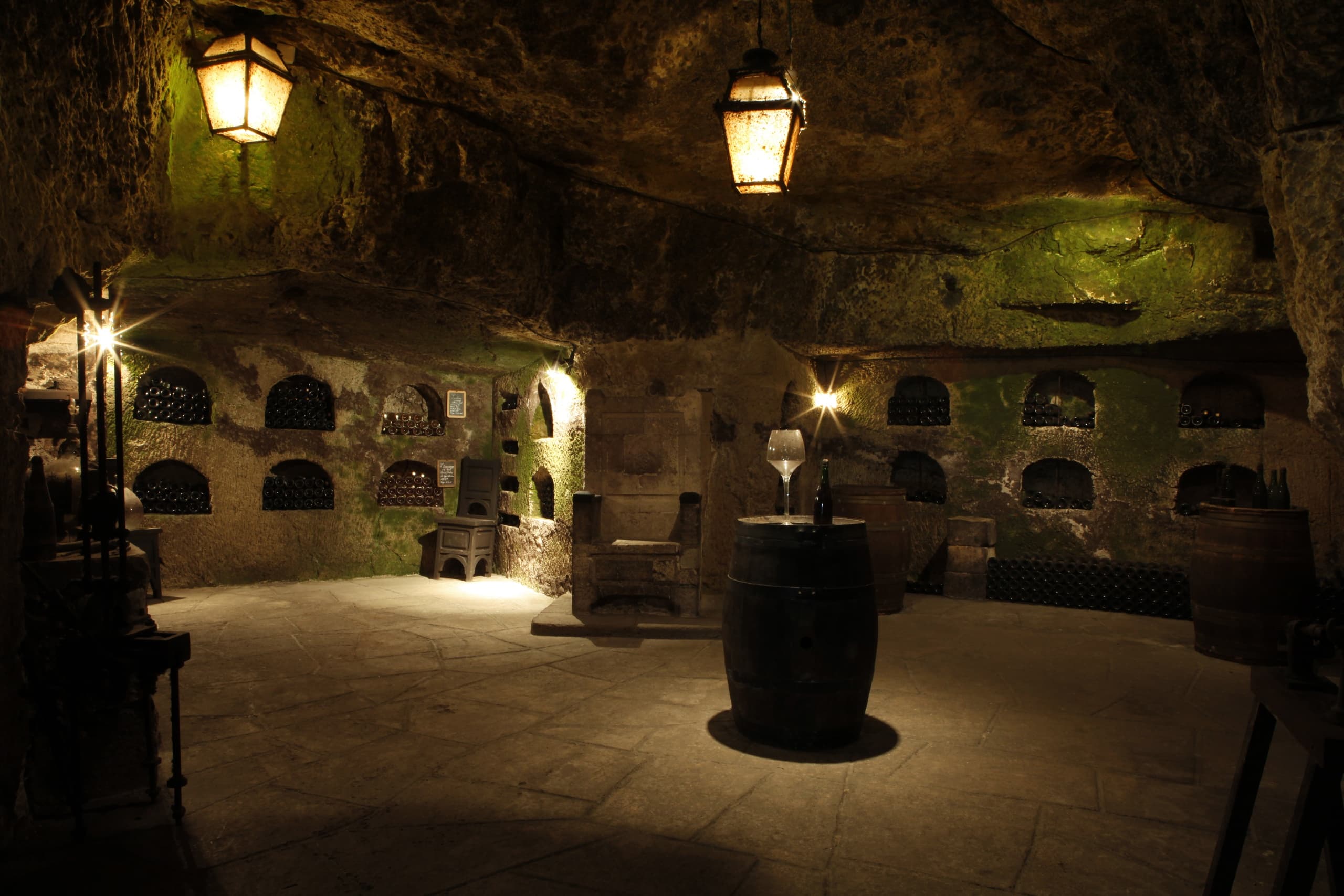 Dimly lit underground wine cellar with barrels for tastings