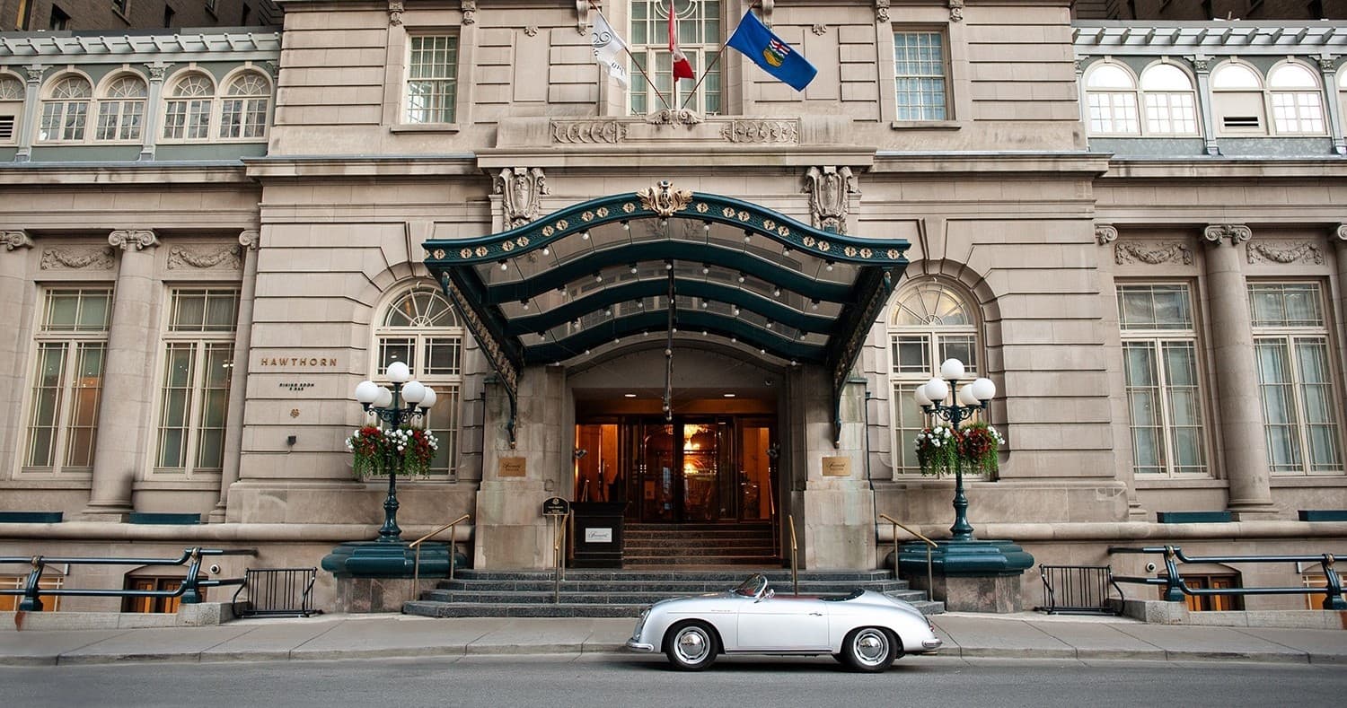 Historic hotel facade on city street with classic car