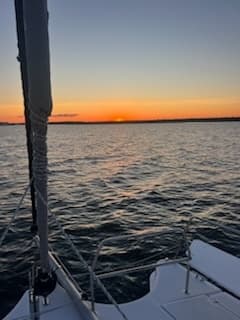 Sunset from sailboat bow over open lake waters