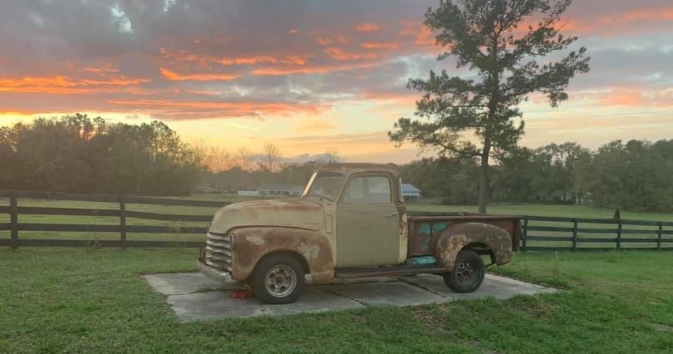 Vintage pickup truck at sunset on a scenic farm pasture