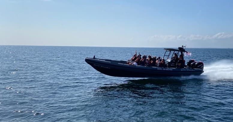 Coastal RIB boat cruising calm sea with panoramic horizon view