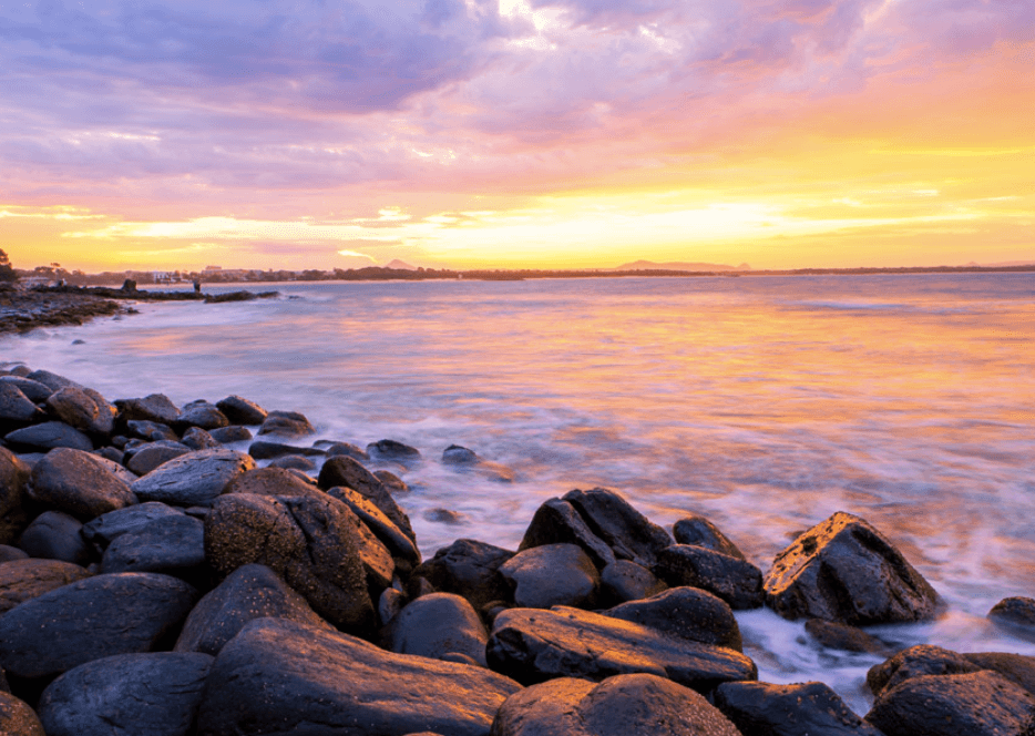 Rocky shoreline at sunset, vibrant coastal vista for cruises