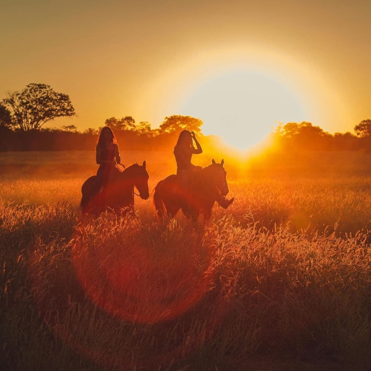 Sunset horseback riding across Texas prairie at golden hour