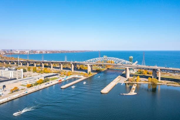 Aerial view of coastal harbor and bridge with moored boats