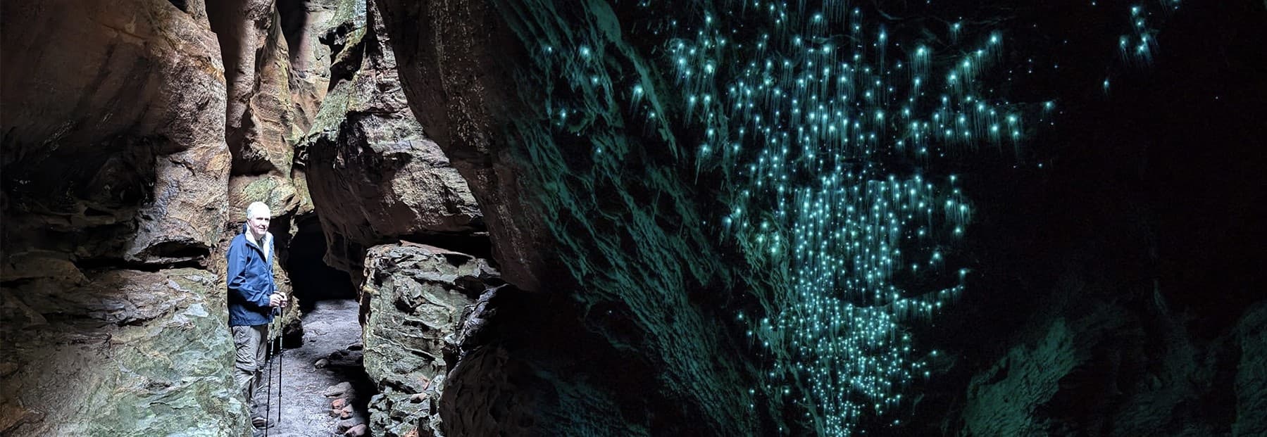 Cavern glowworm display beside canyon with spelunkers