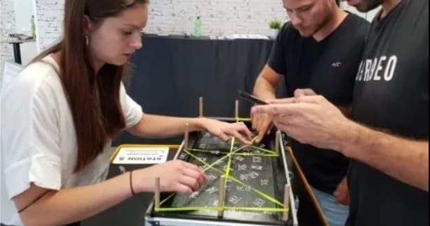 Close-up collaborative team-building challenge indoors with sticks