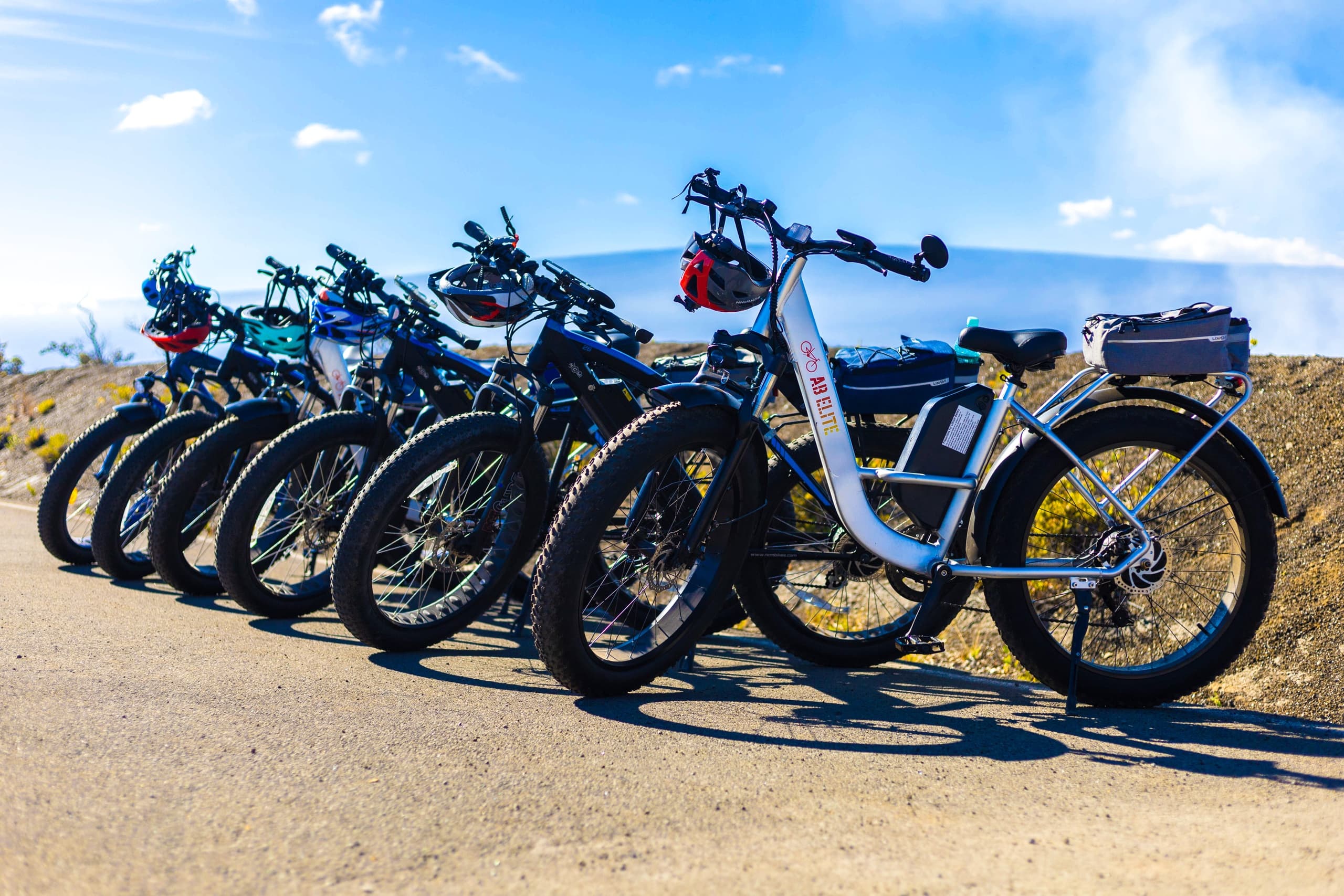 Lineup of electric bikes parked along scenic coastal road Hawaii