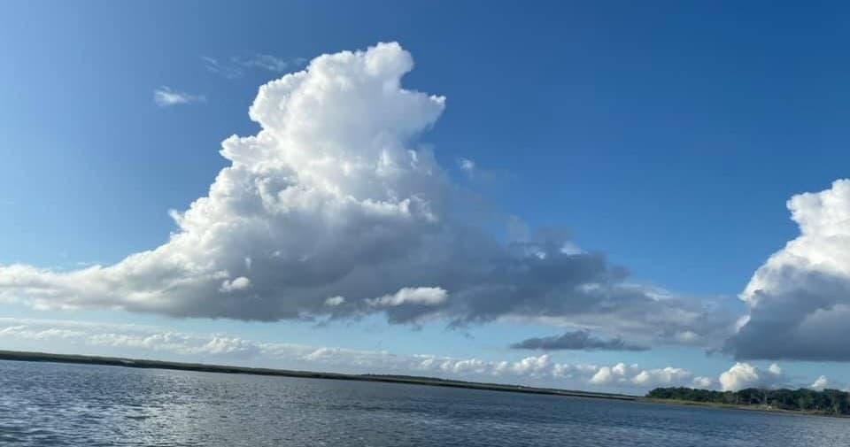 Dramatic cumulus clouds above estuary waters, ideal for coastal cruising