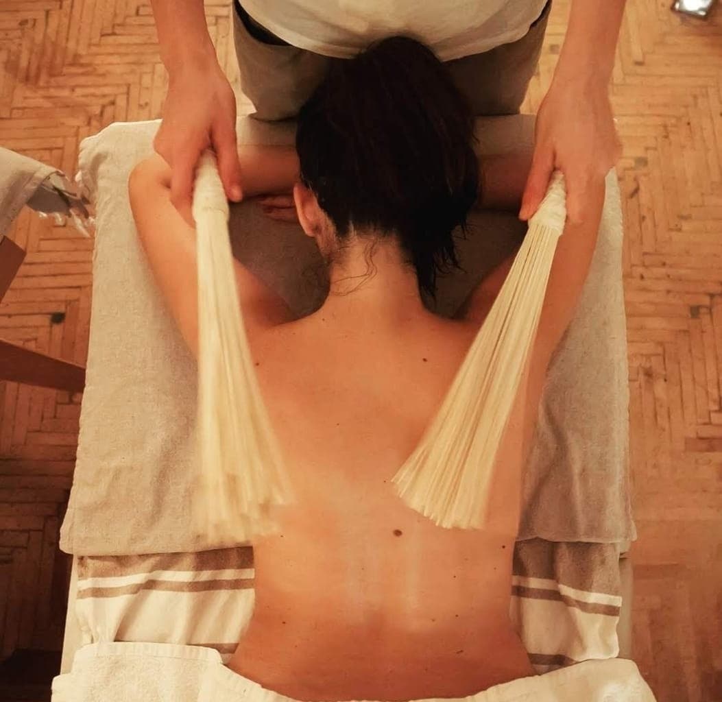 Back massage using silk tassel brushes in Otium Spa treatment room