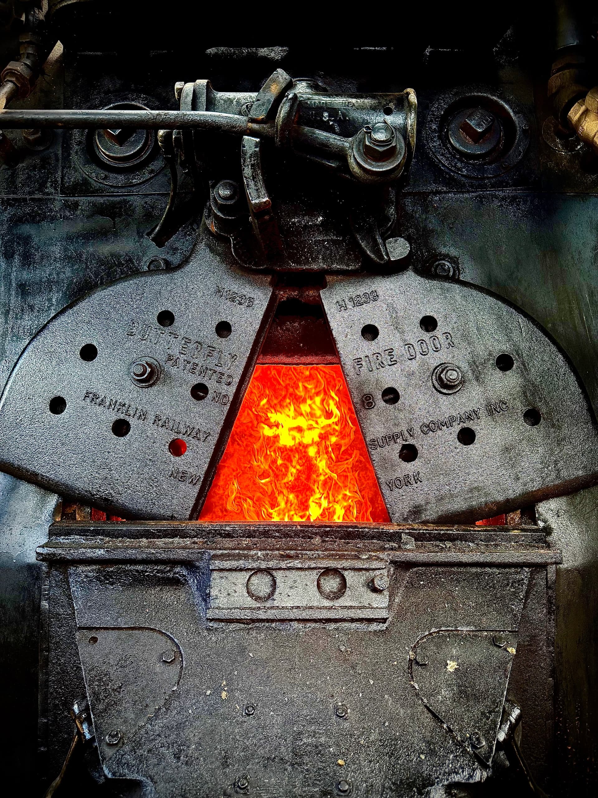 Hot steam engine firebox glowing during locomotive steam operation