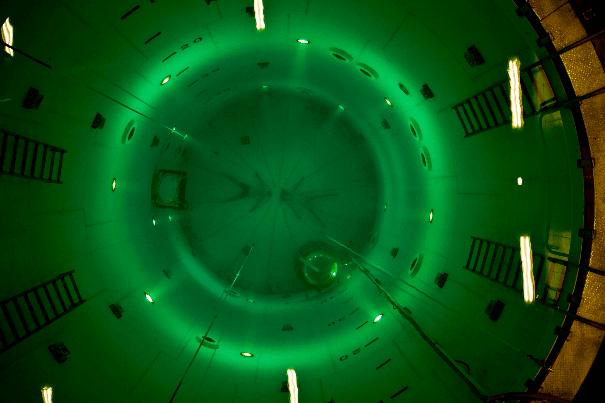 Indoor aquatic survival training tank with green-lit circular pool