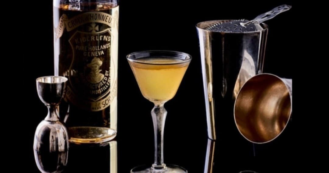 Classic cocktail tools and mixed drinks set against black