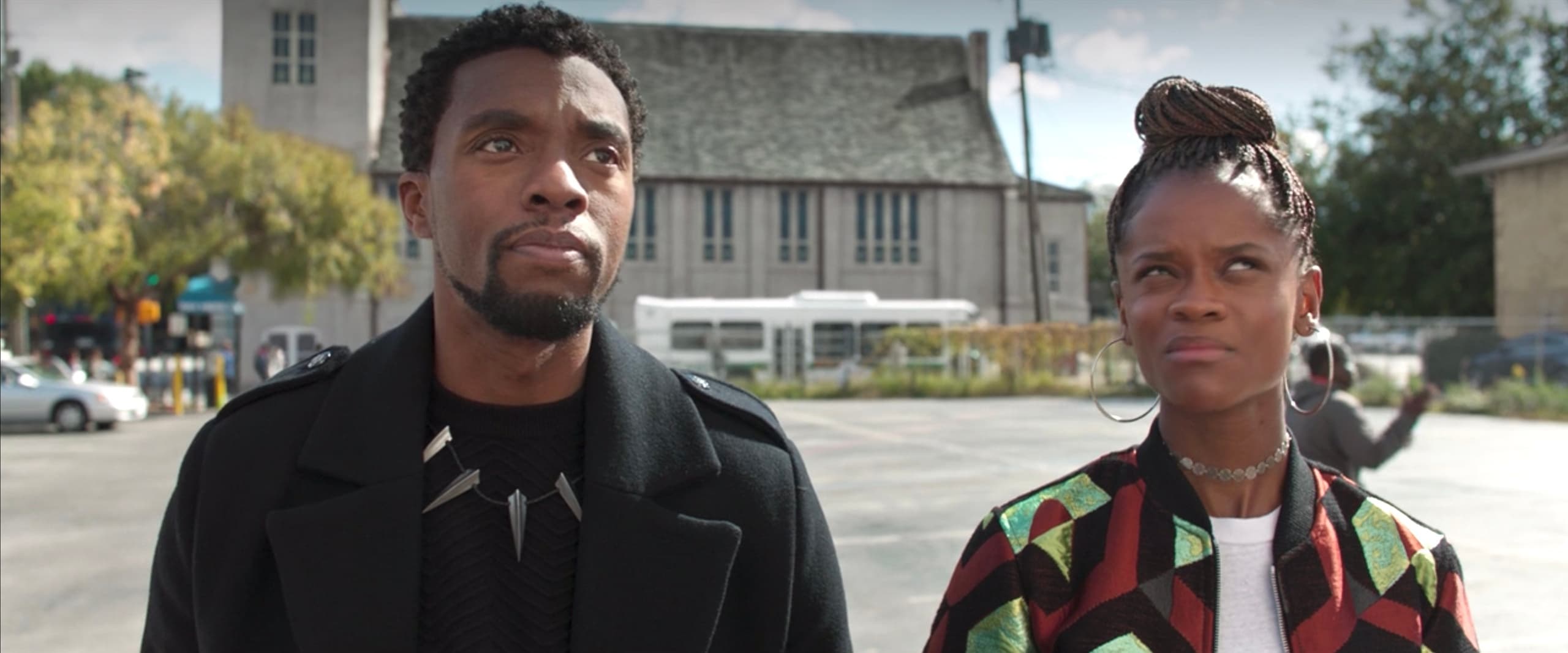 Two people standing in urban plaza, film location tour scene