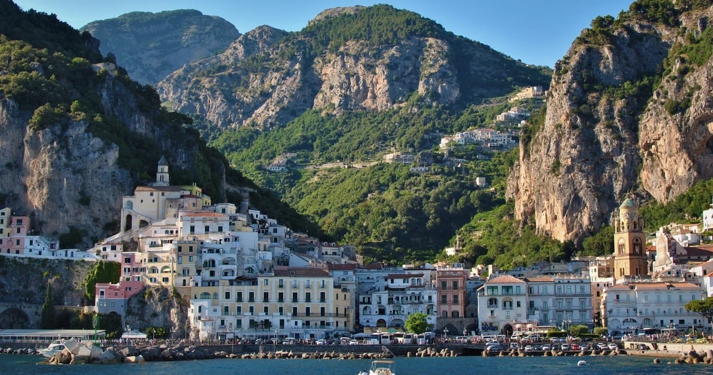 Cliffside Mediterranean town at sunset overlooking serene beach