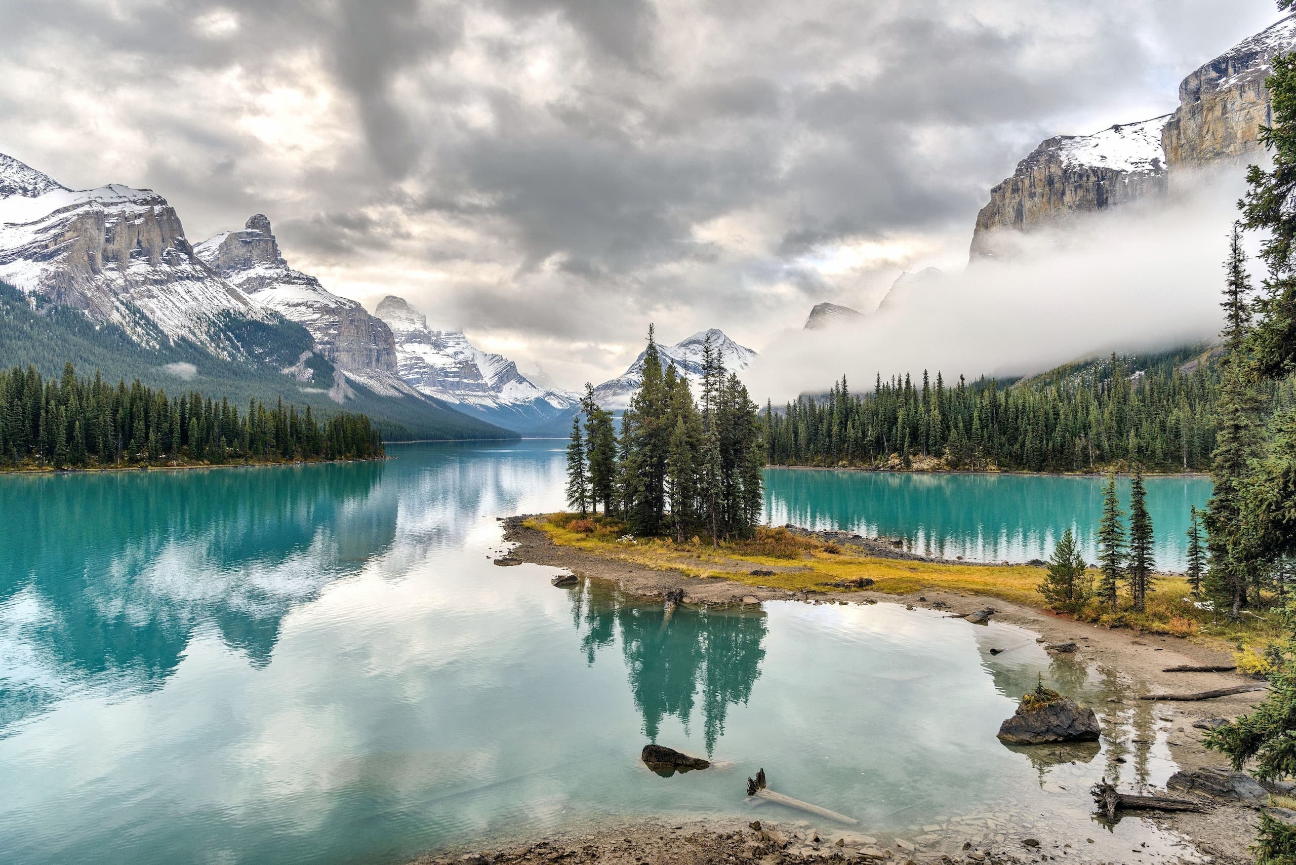 Crystal-clear glacial lake reflecting mountains and forest in Banff