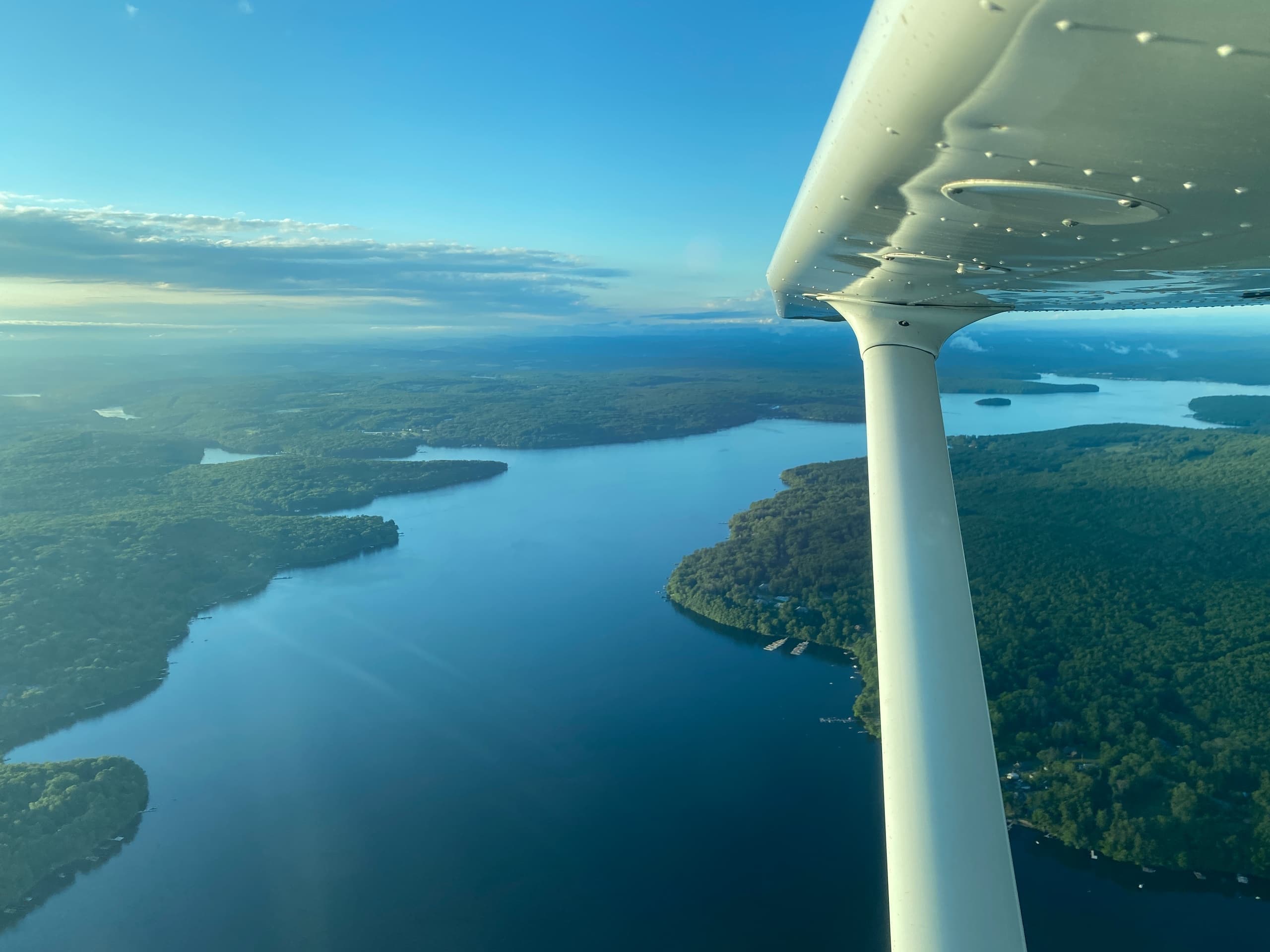 Coastline and lake viewed from airplane wing over water