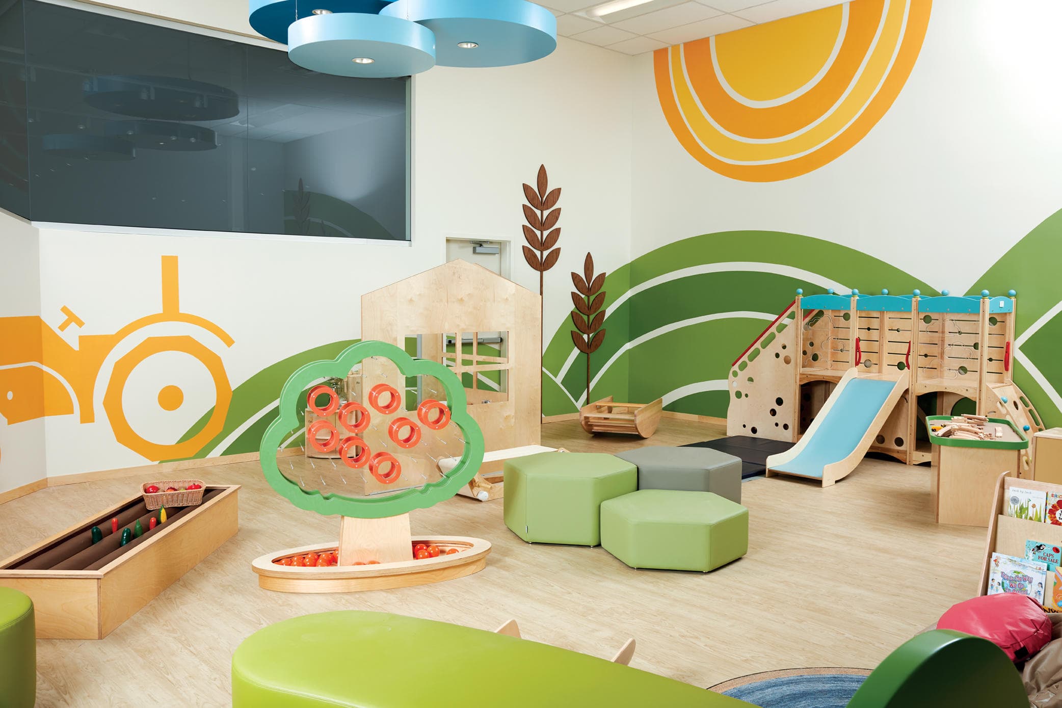 Indoor children's play area with colorful mural and soft seating