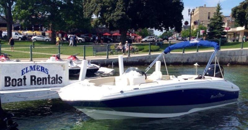 Docked rental bowrider at marina shoreline, calm summer day