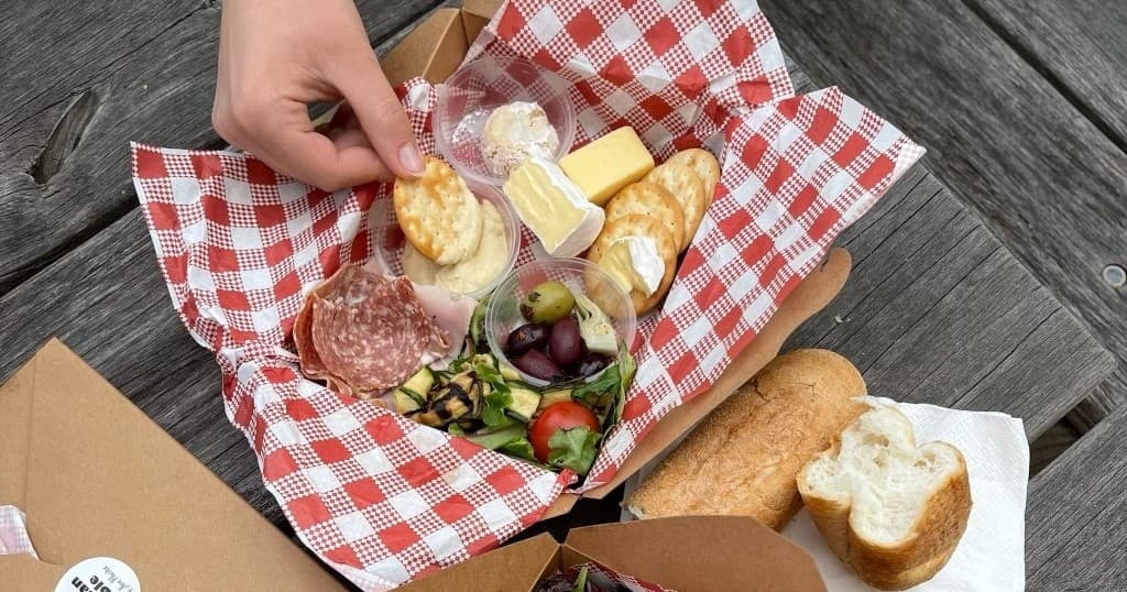 Outdoor picnic charcuterie board on rustic park picnic table
