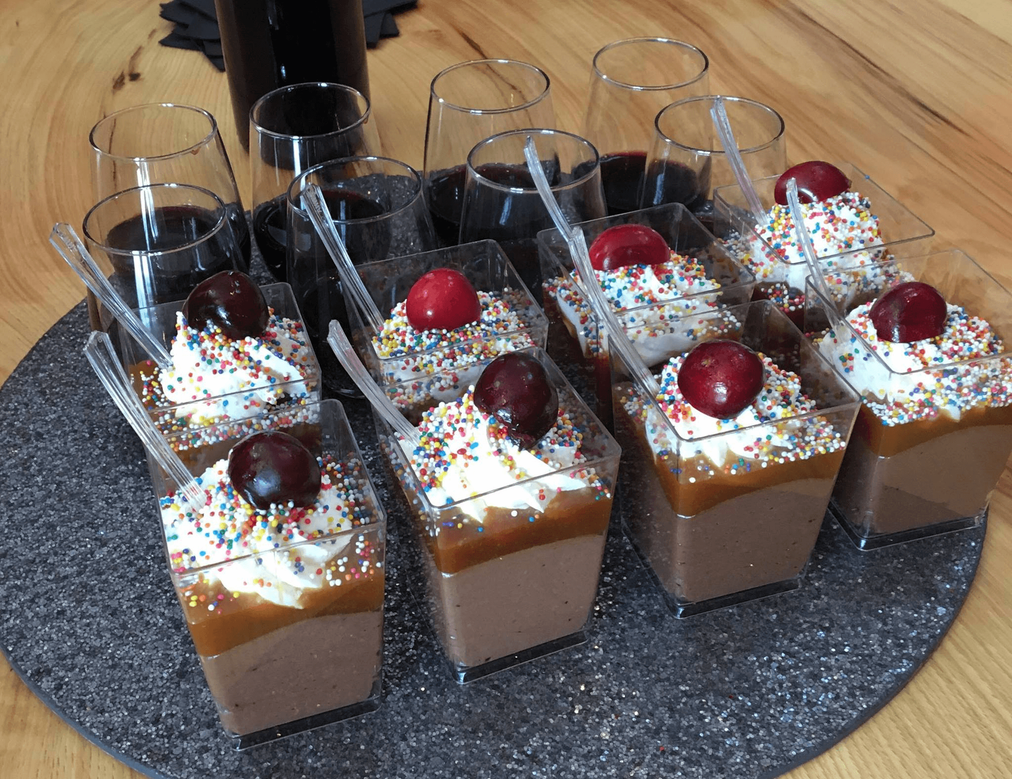 Individual dessert cups with whipped cream and cherries at tasting