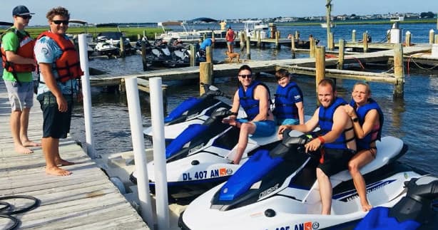 Friends on jet skis at marina dock preparing for Atlantic tour