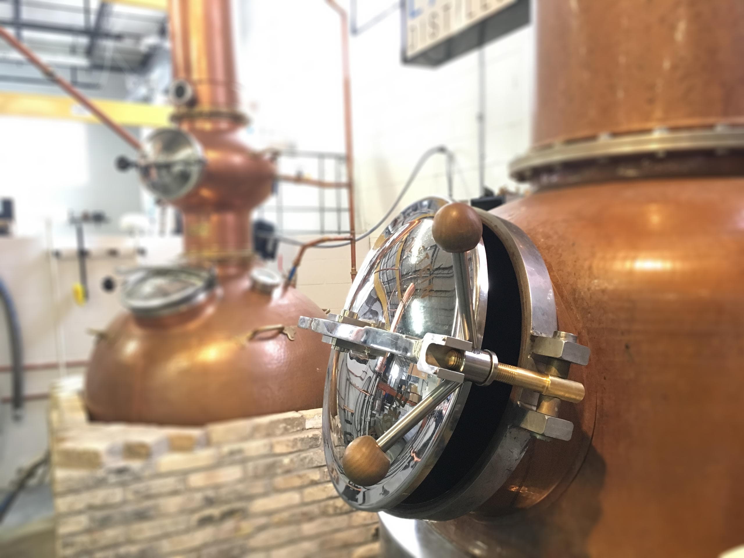 Close-up of copper pot still in distillery production room