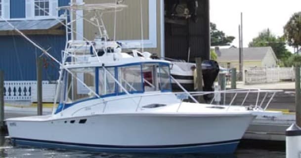 Sportfishing boat moored at marina near shore, ready to depart