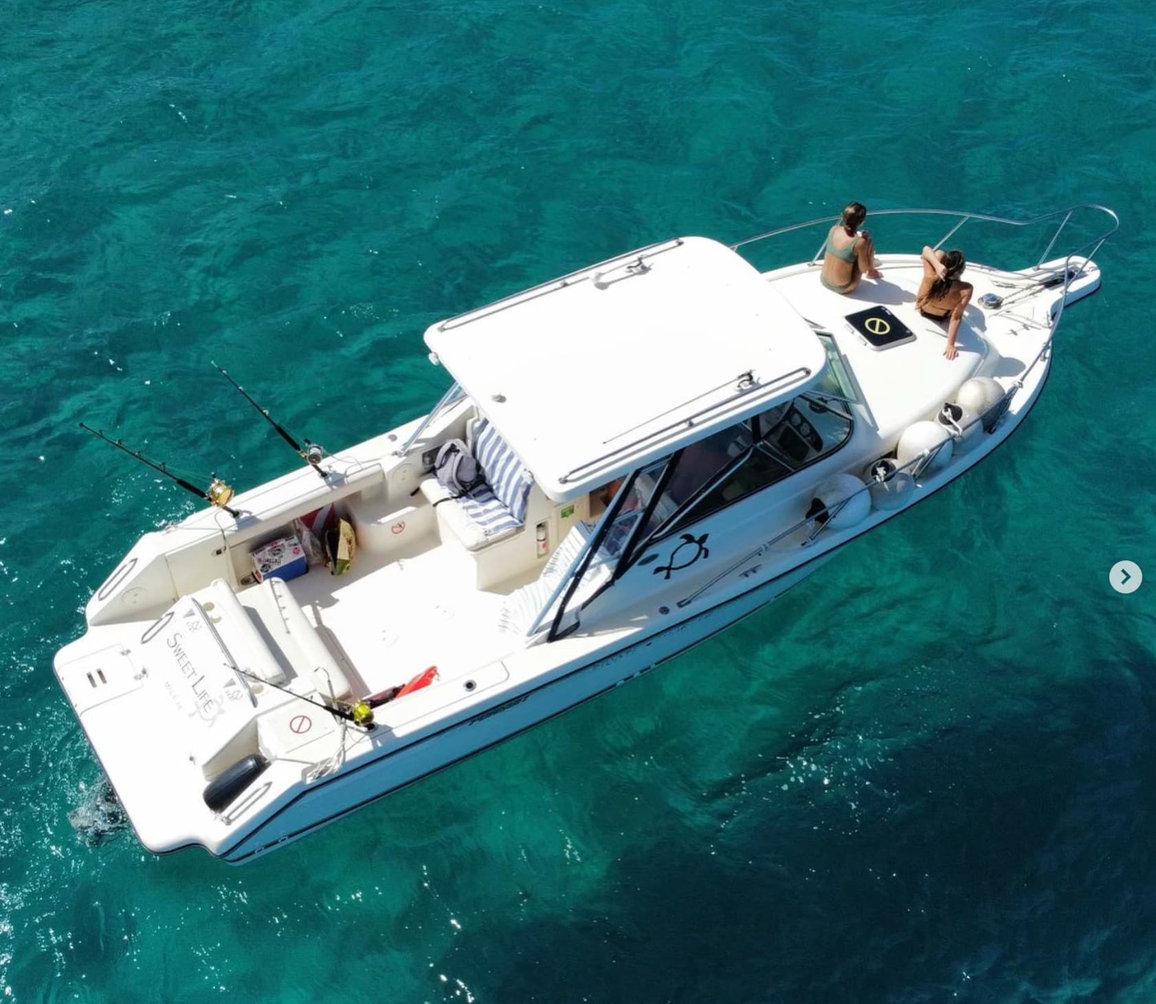 Aerial fishing boat over clear turquoise Pacific waters