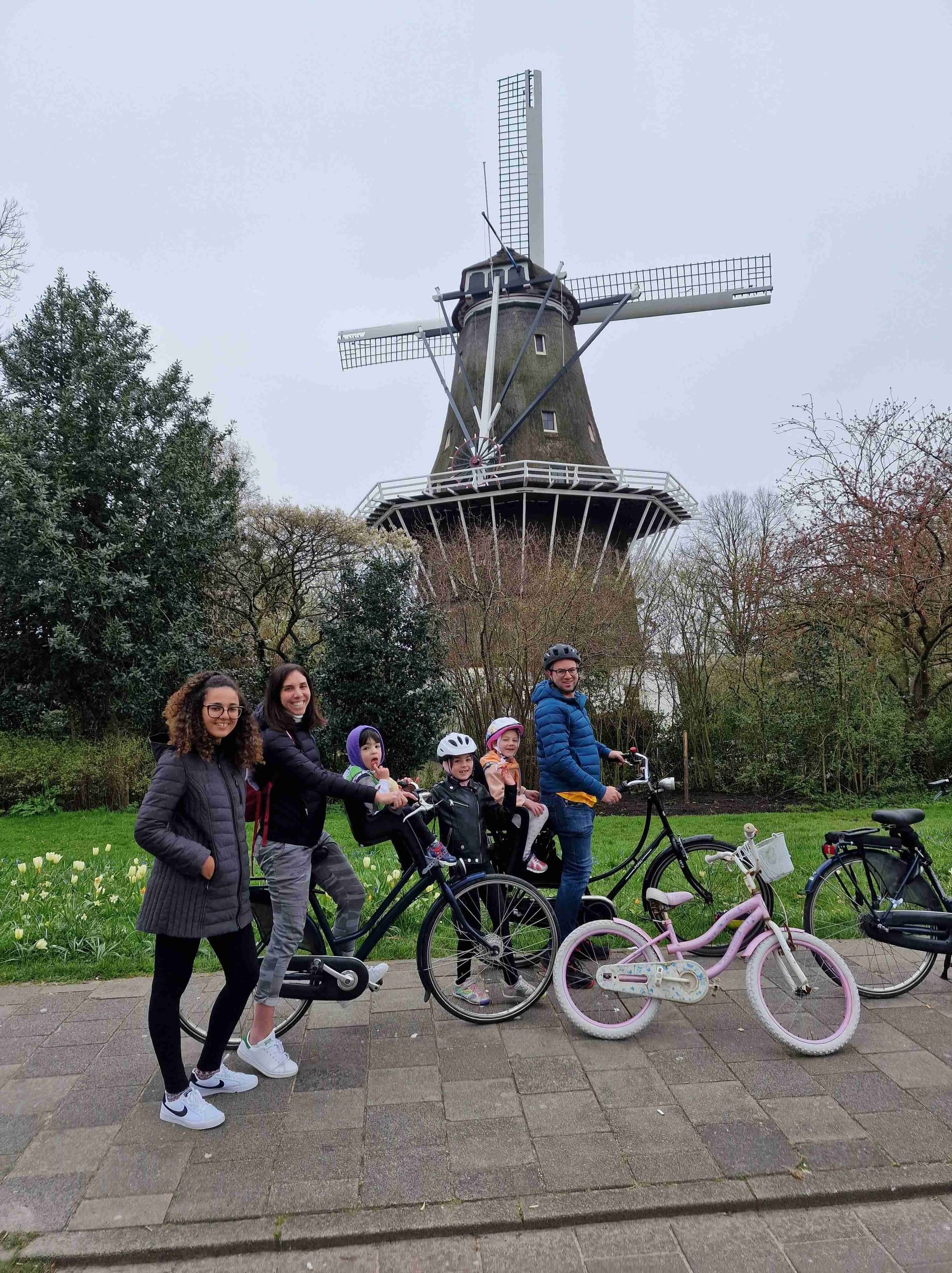 Family and children posing with bikes before historic windmill