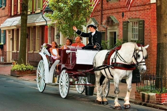 Victorian horse-drawn carriage on cobblestone street, historic tour
