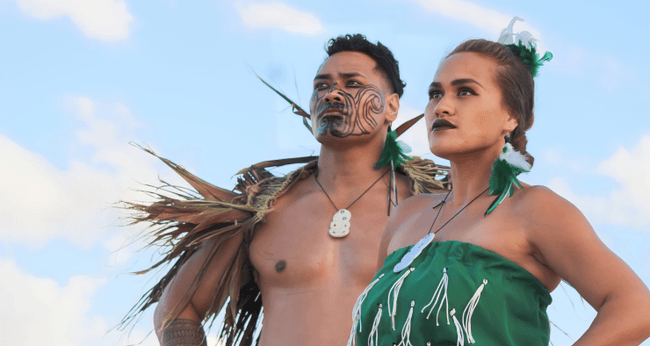 Close-up of Hawaiian duo in traditional attire at luau