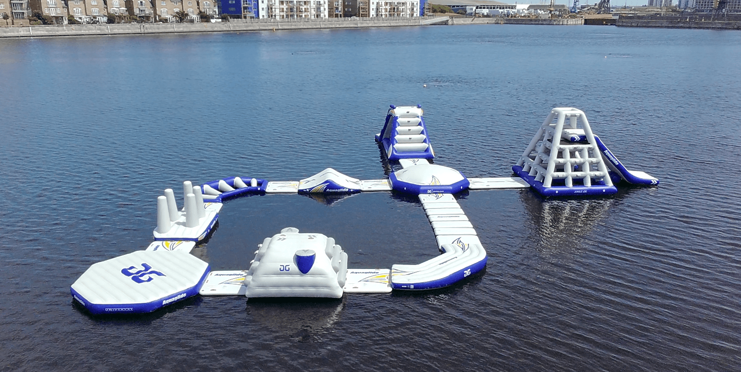 Floating inflatable waterpark platform on calm marina water, family fun
