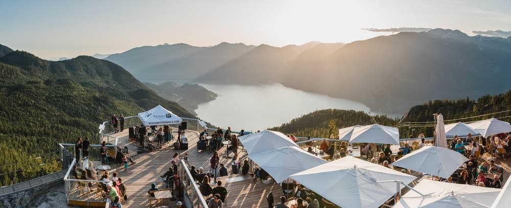 Scenic mountaintop viewpoint with tents overlooking coastal fjord