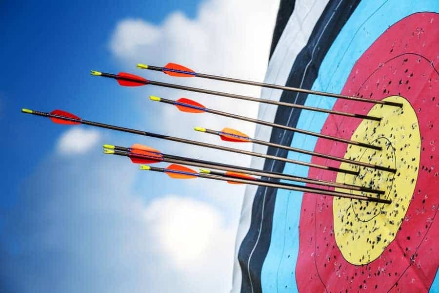 Cluster of arrows striking bullseye on outdoor archery target