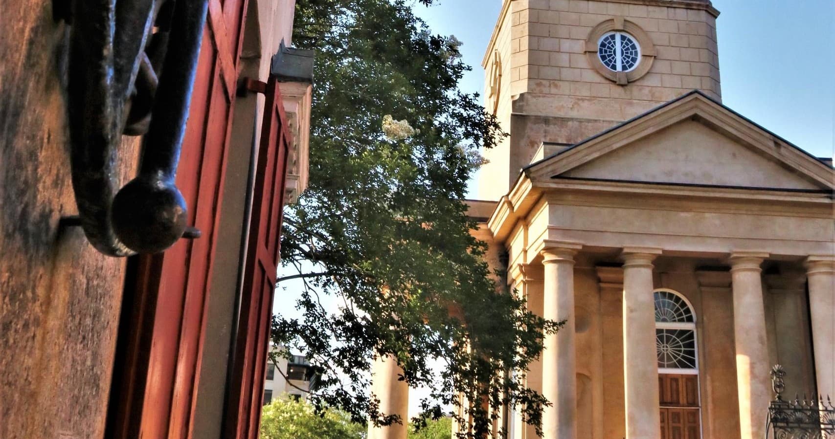 Historic church facade by tree-lined street on Charleston tour