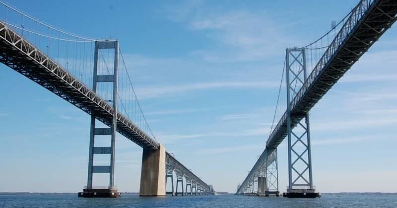 Scenic suspension bridge over calm water, coastal shipping channel