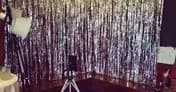 Sequin backdrop with tripod and studio lights at indoor party setup