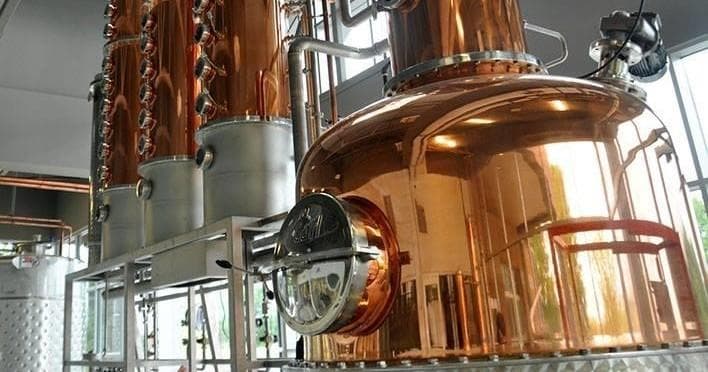 Copper stills and distillation equipment inside craft distillery