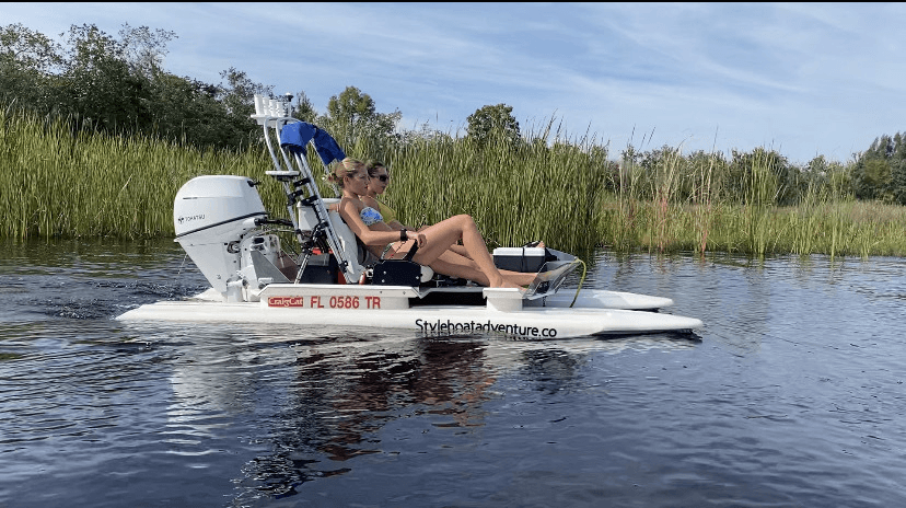 Small motorboat cruising marsh wetlands with passengers relaxing