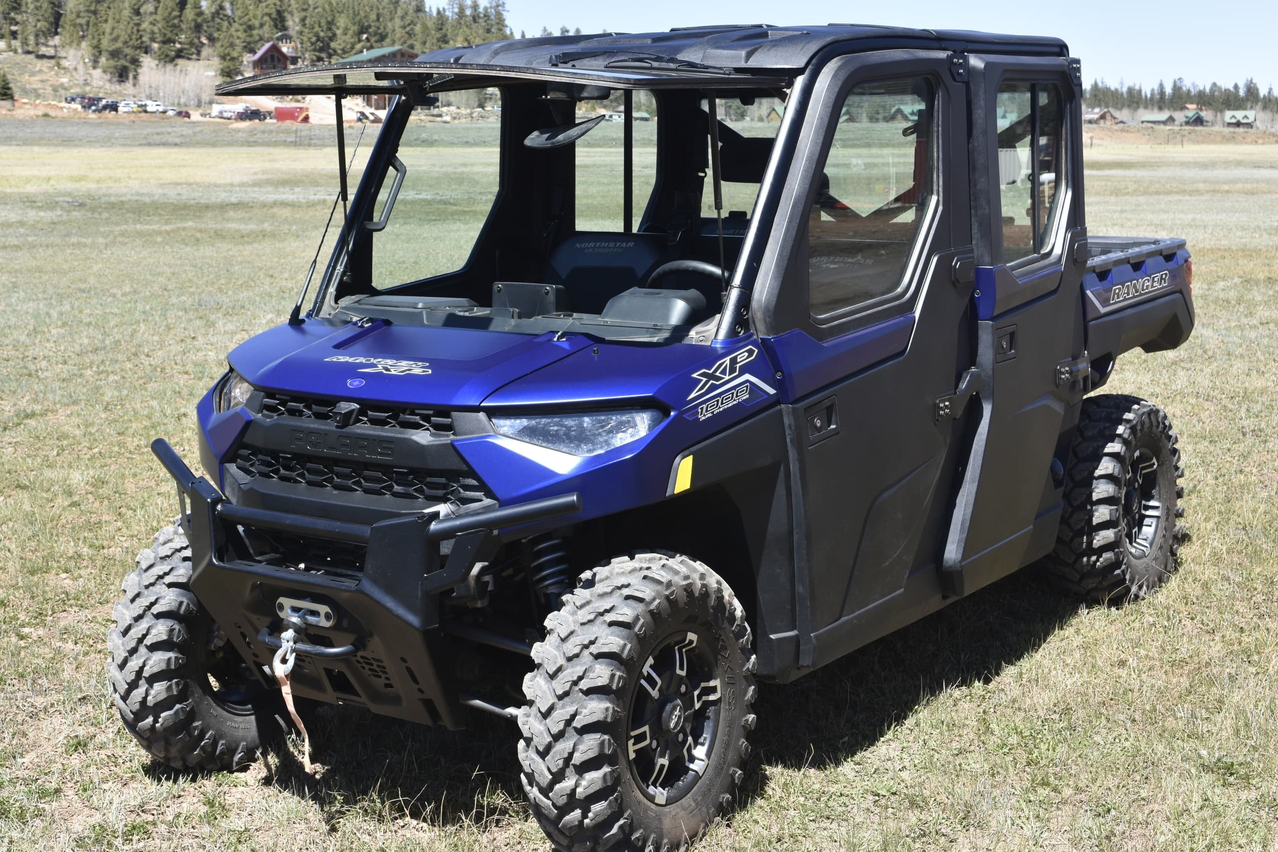 Four-seater utility terrain vehicle on open field for off-road tour