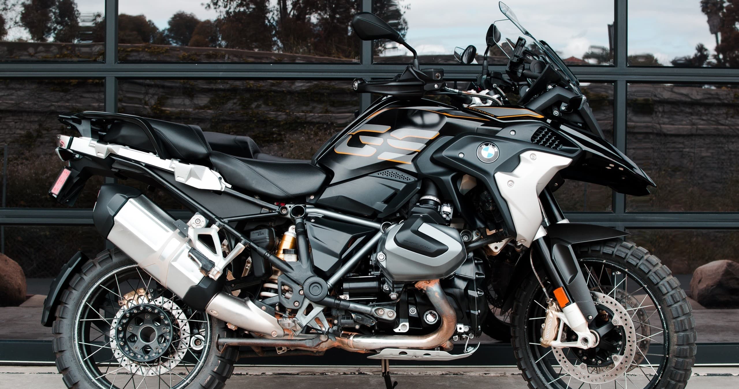 Adventure motorcycle parked by glass wall for coastal touring