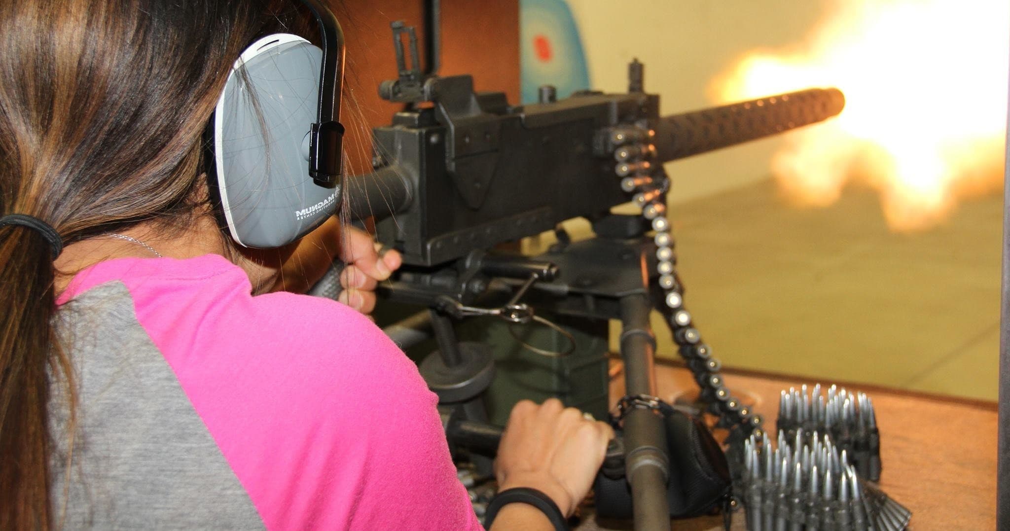 Woman aiming rifle outdoors at sunset during tactical shooting practice