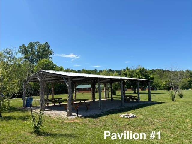 Open-air pavilion under blue sky at family resort picnic area